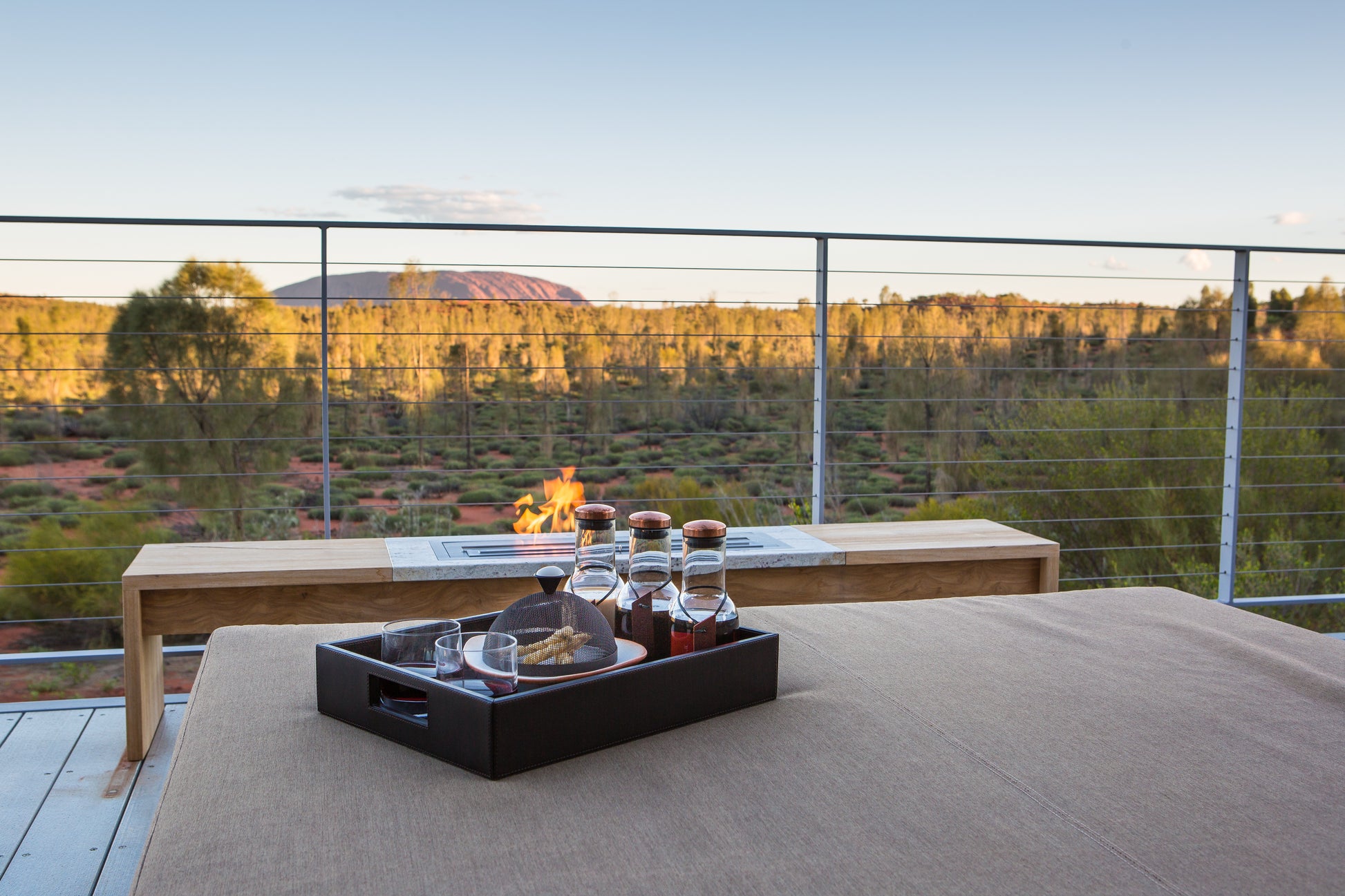 Outdoor setting with a table and tray of drinks on a deck with scenic view
