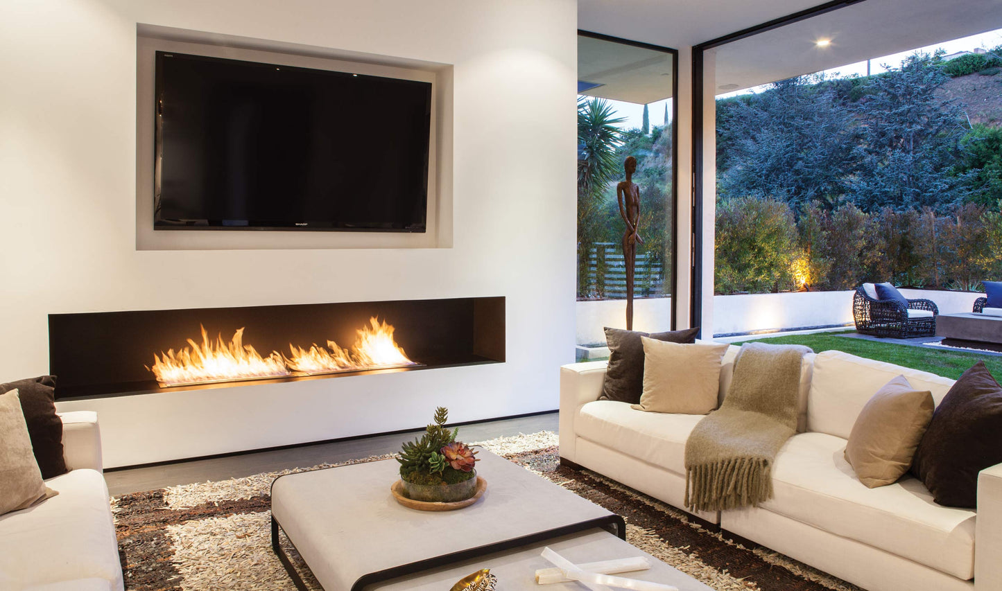 Modern living room with a fireplace, TV, and outdoor view