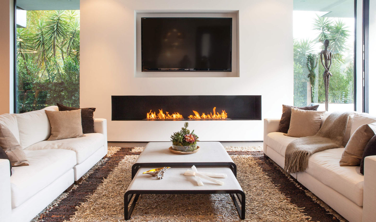 Modern living room with white sofas, a coffee table, and a fireplace.