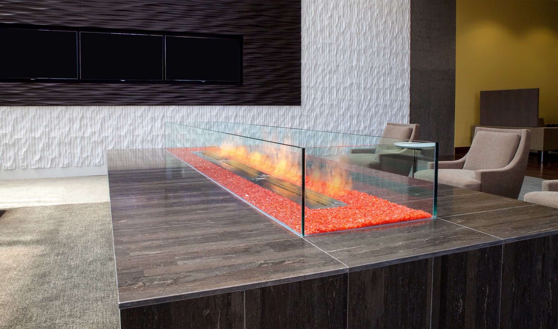 Modern indoor fireplace with glass cover in a living room setting.