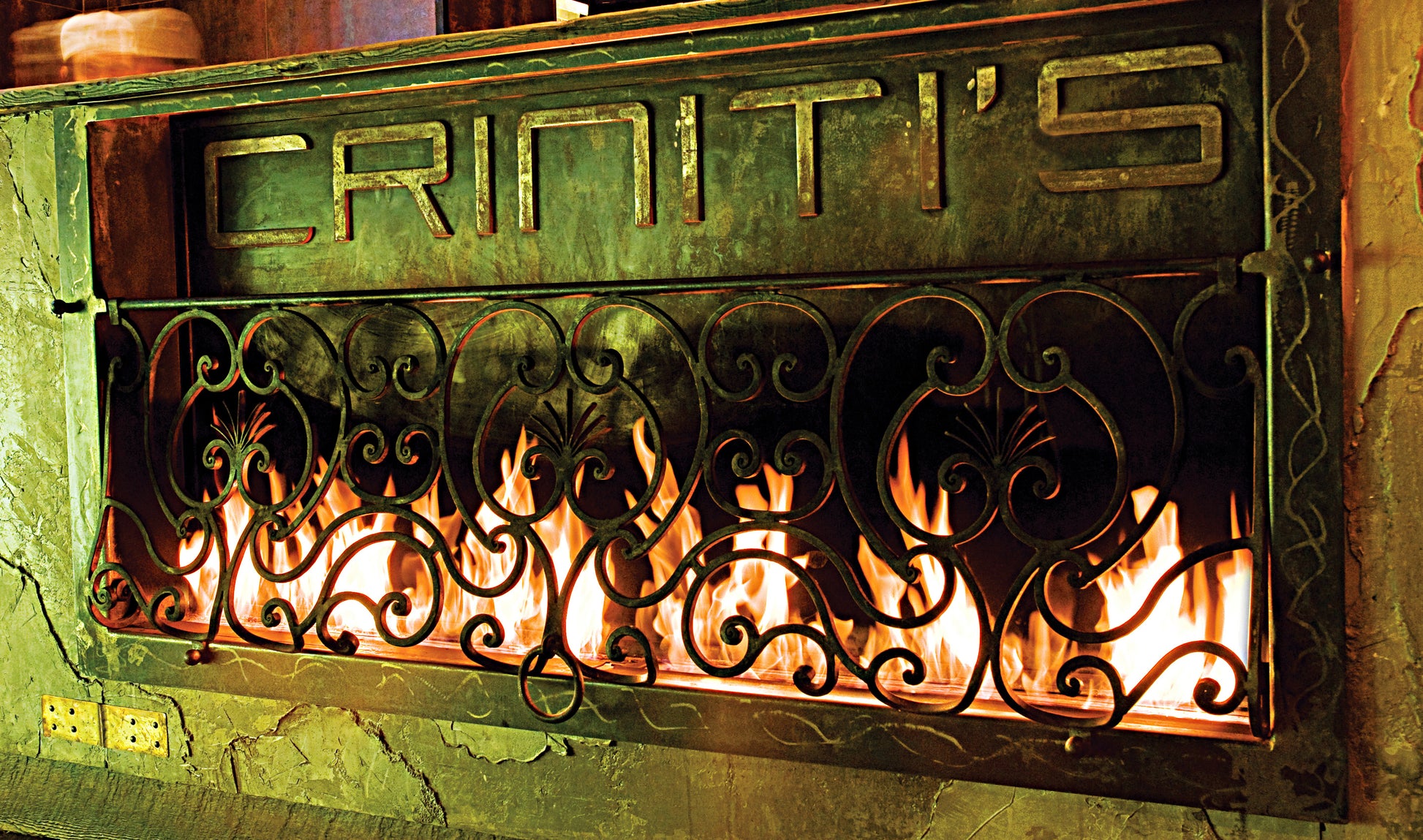 Decorative fireplace cover with 'Criniti's' branding and visible flames.