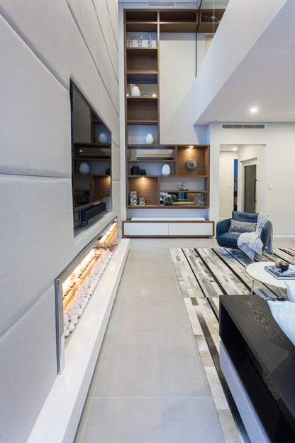 Modern living room with a built-in entertainment unit and decorative elements.