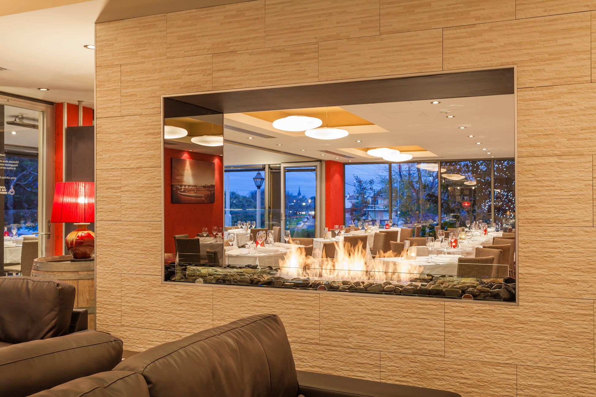 Large mirror reflecting a dining area with a modern interior design.