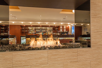 Modern bar interior with a large mirror reflecting the bar area.