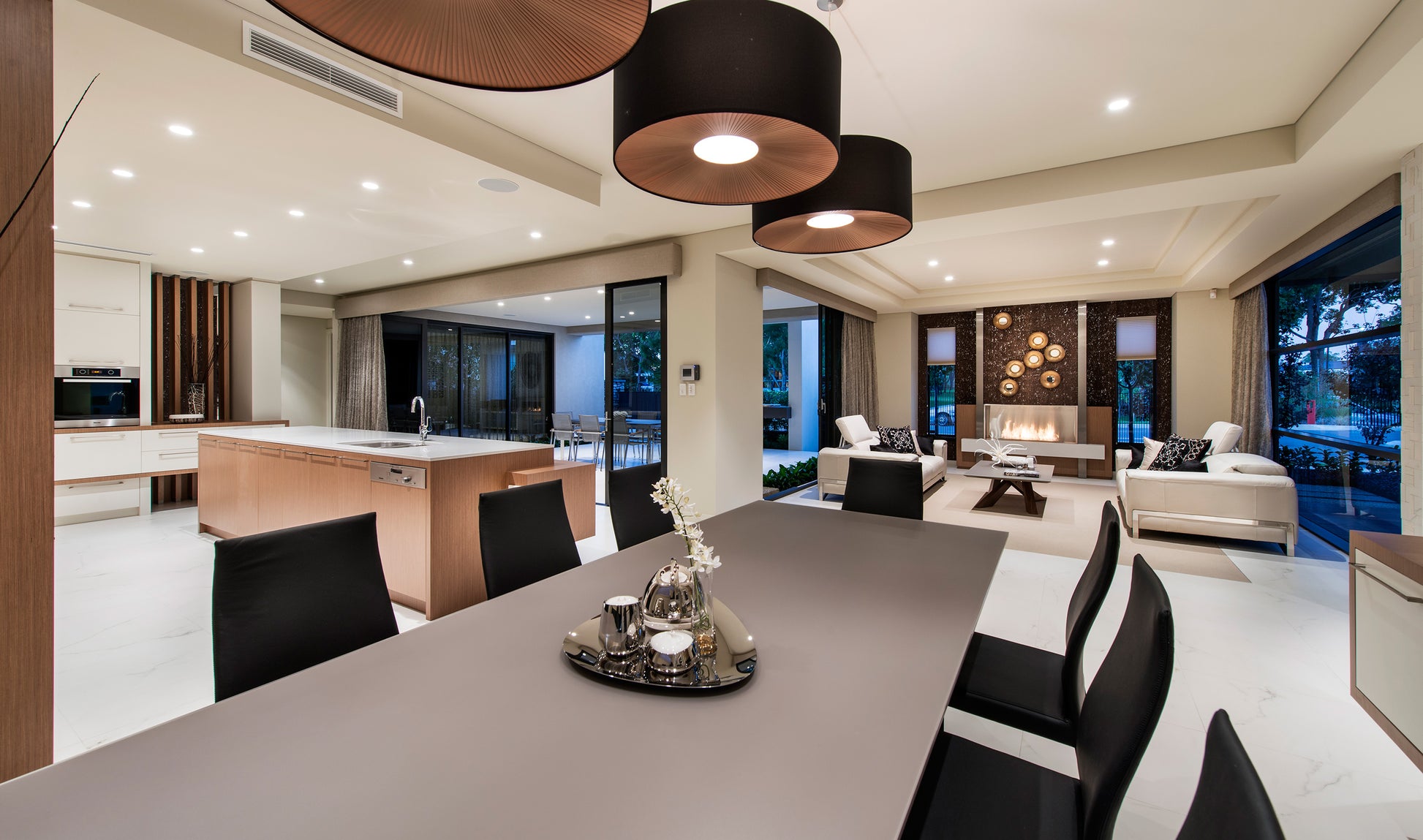 Modern kitchen and living room with a dining table in the foreground.