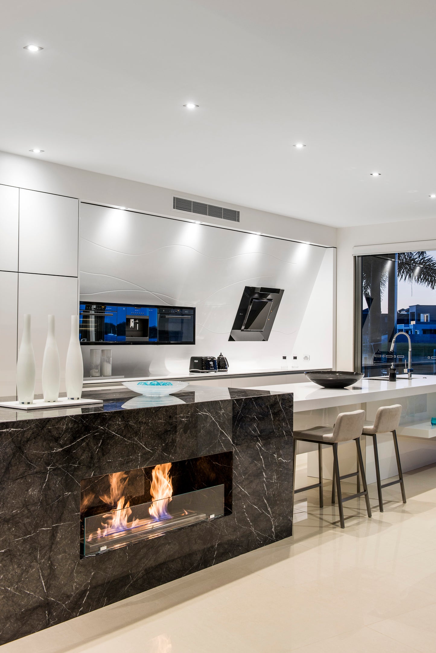 Modern kitchen with a built-in fireplace and white cabinetry.