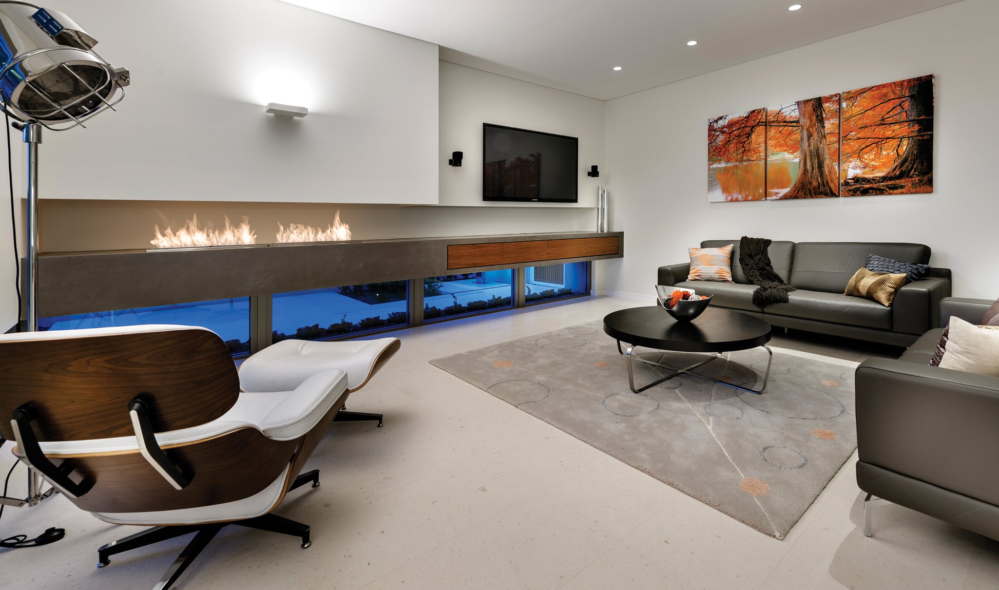 Modern living room with a fireplace, TV, and decorative wall art.