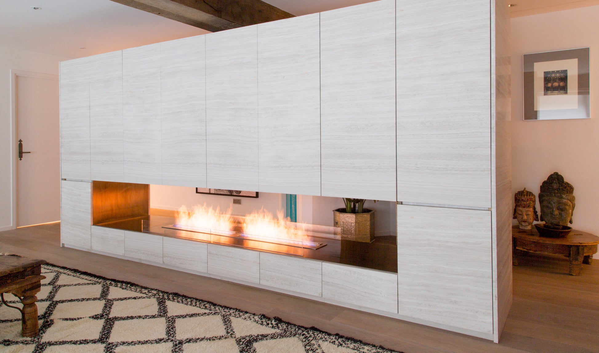 Modern white wall with built-in fireplace and decorative elements in a room.