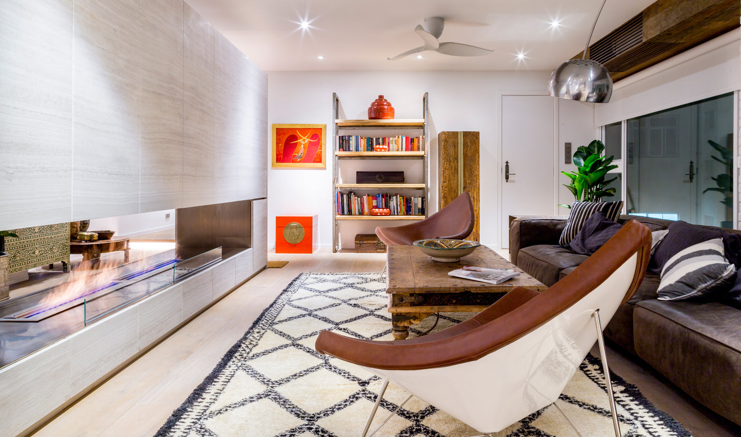 Modern living room with a fireplace, bookshelf, and comfortable seating.