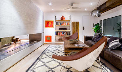 Modern living room with a fireplace, bookshelf, and comfortable seating.