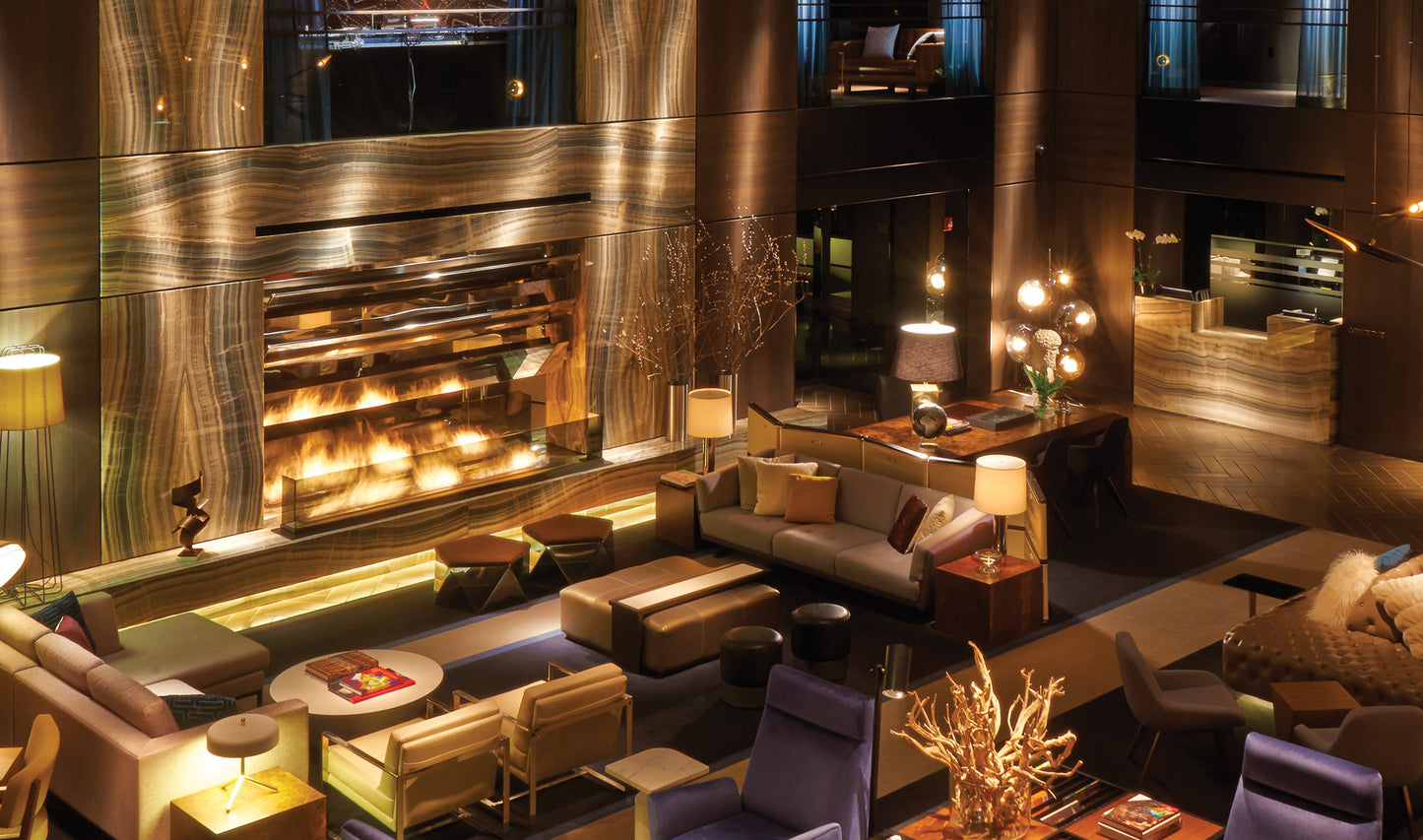 Luxurious interior of a lounge with a large fireplace, modern furniture, and decorative elements.