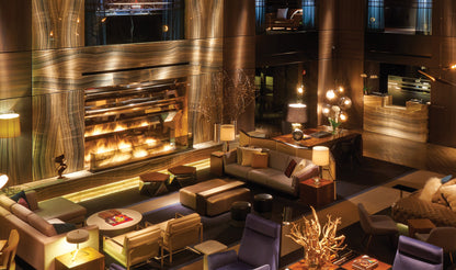 Luxurious interior of a lounge with a large fireplace, modern furniture, and decorative elements.