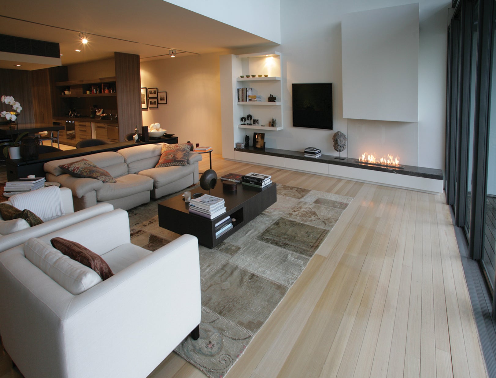 Modern living room with white sofa, coffee table, and fireplace.