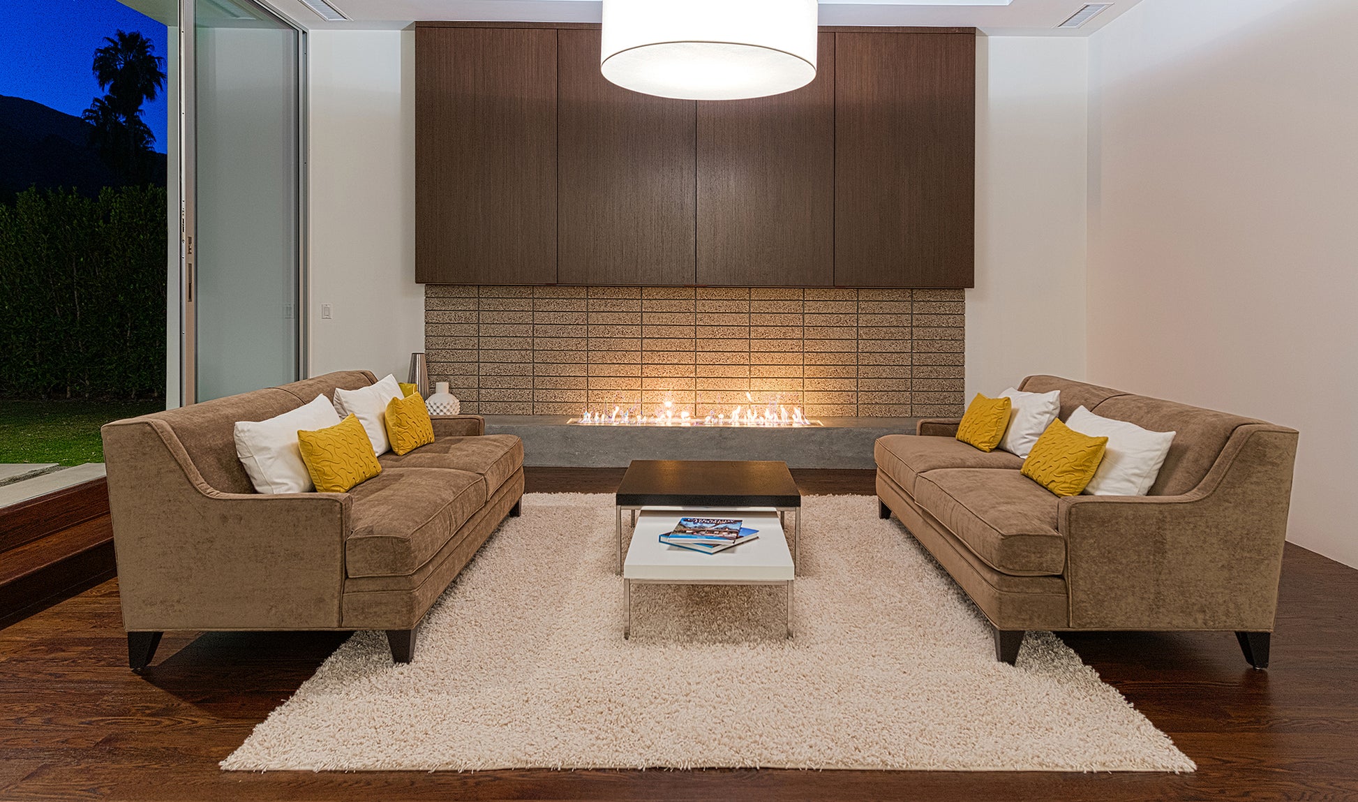 Modern living room with brown sectional sofa, coffee table, and fireplace.