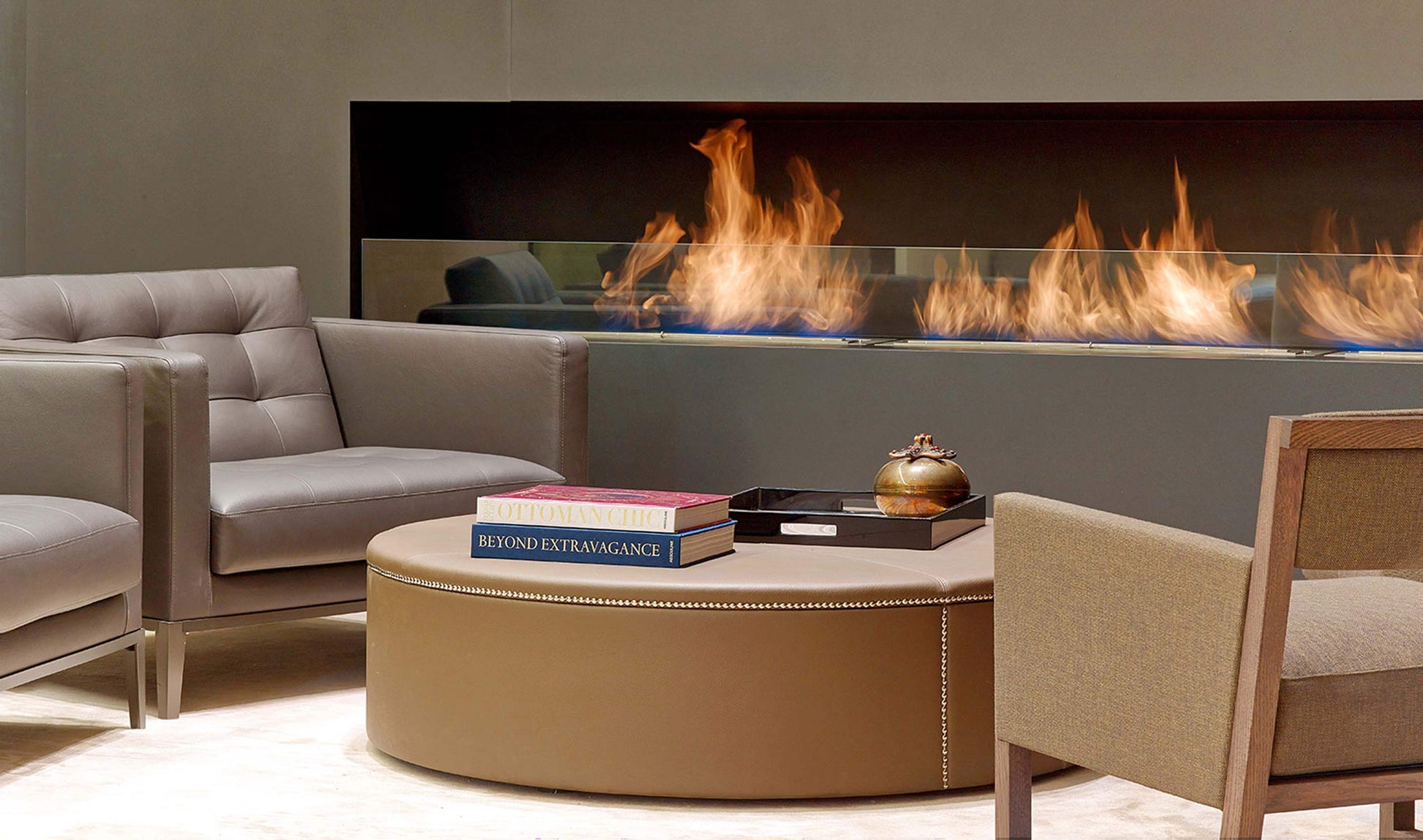 Modern living room with a gas fireplace, gray sofa, and beige armchair.
