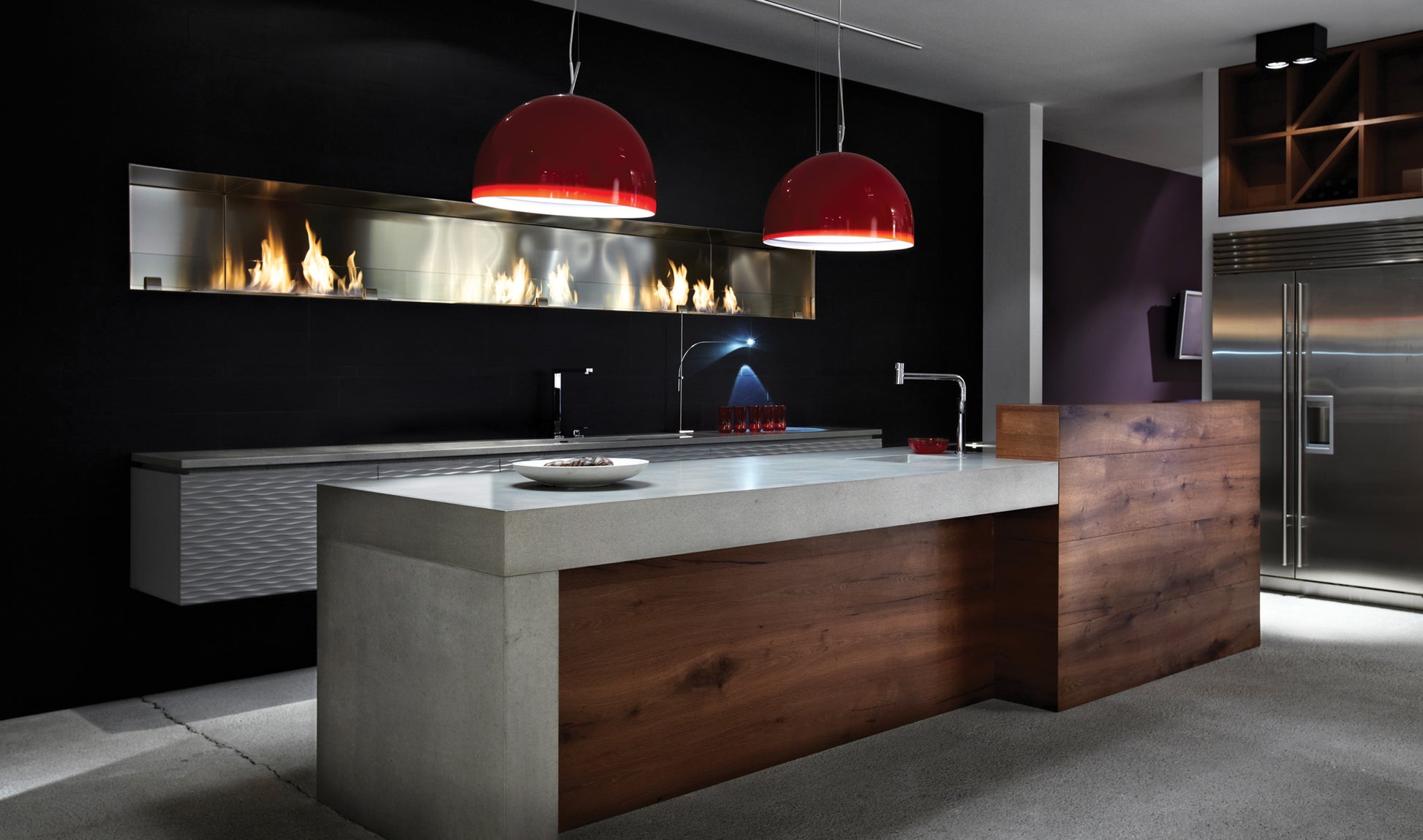 Modern kitchen with a island, red pendant lights, and dark walls.