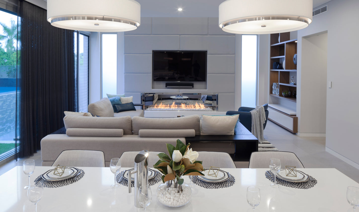Modern living room with a dining table set, fireplace, and television.