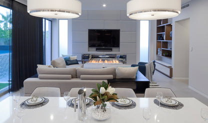 Modern living room with a dining table set, fireplace, and television.