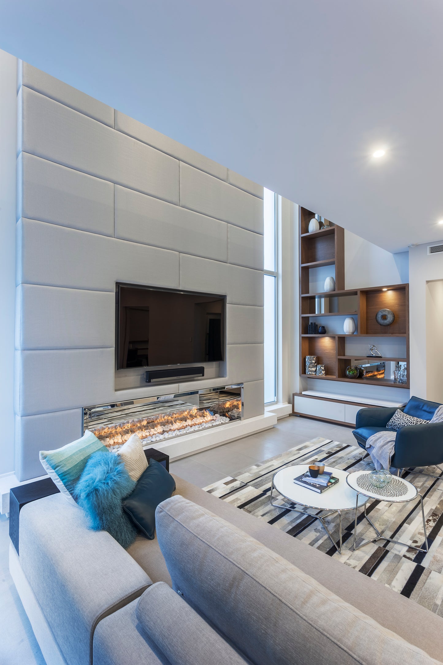 Modern living room with a gray sofa, coffee table, and wall-mounted TV.