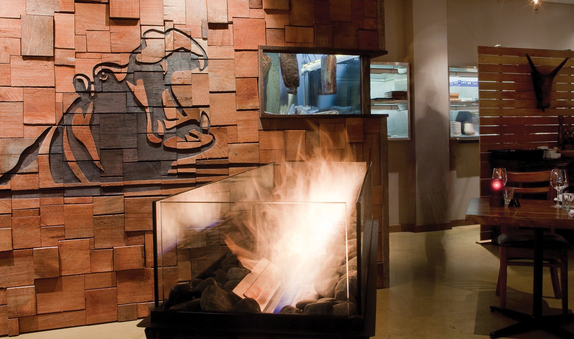 Wooden wall with decorative cutout and fireplace in a restaurant setting