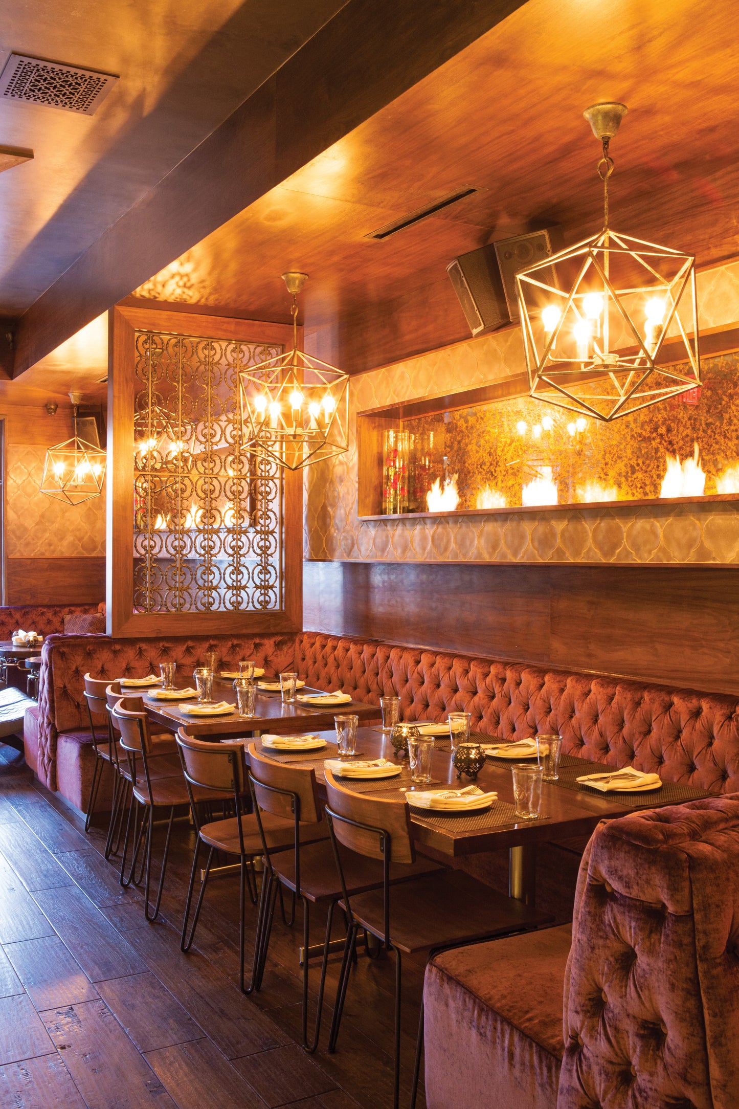 Dining area with red velvet booths and wooden tables in a restaurant.