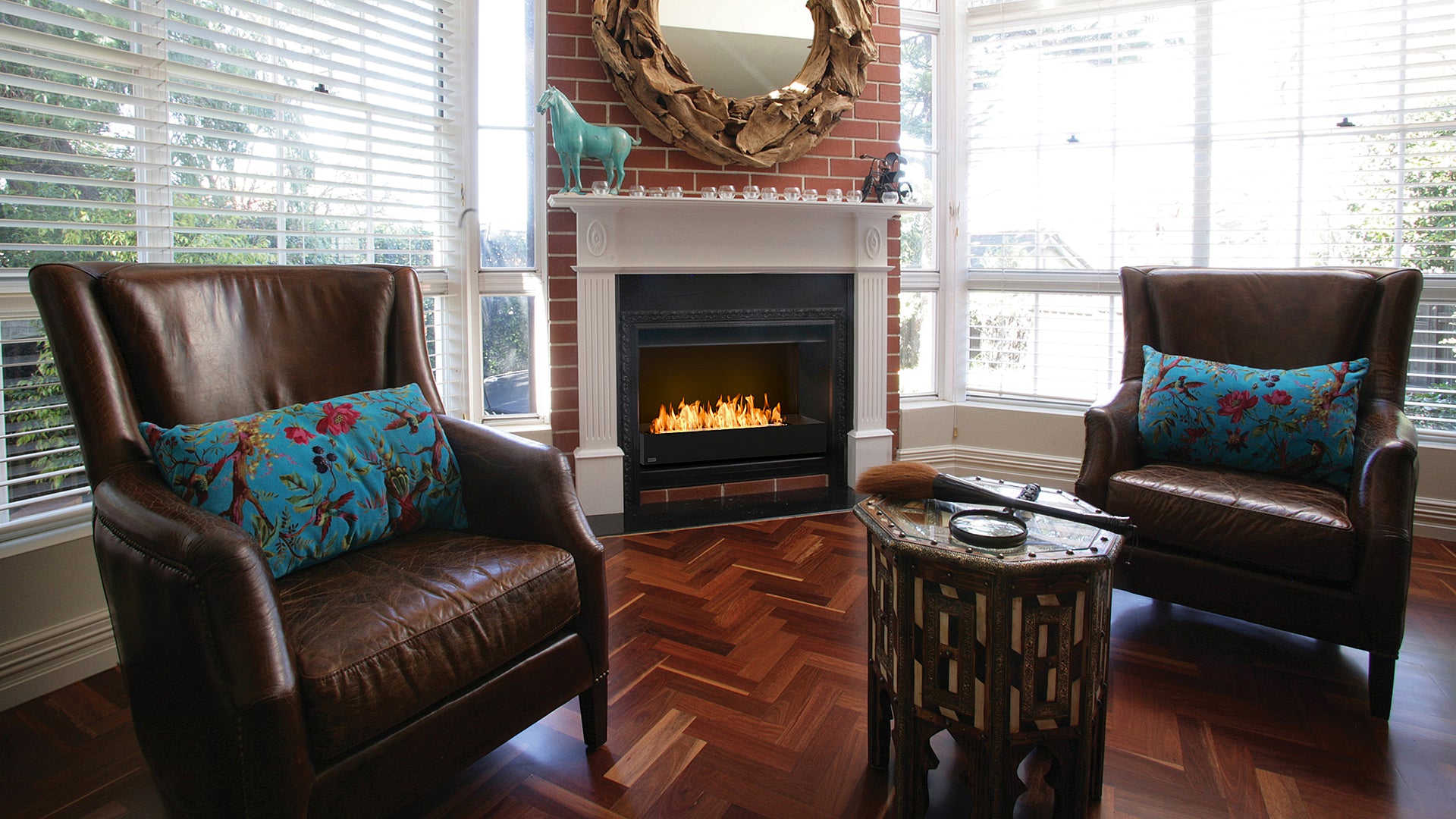Living room with two brown leather chairs, a small table, and a fireplace.
