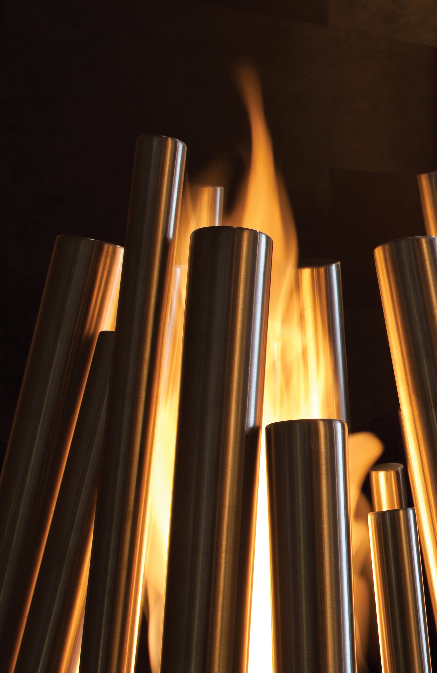 Metallic cylindrical objects with flames in a dark setting